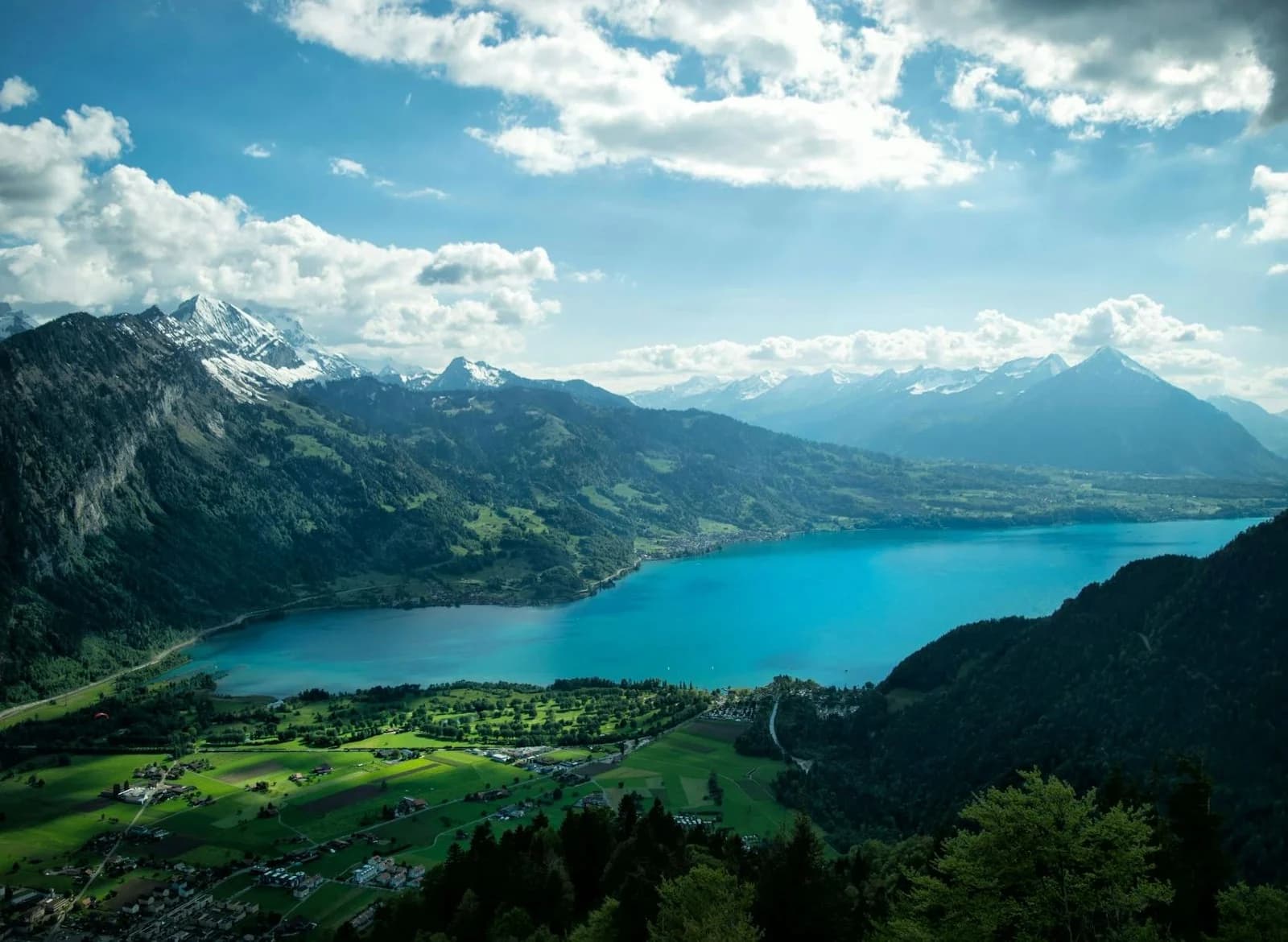 The stunning turquoise waters of Lake Brienz are surrounded by the lush green and snow-capped mountains of the Swiss Alps.