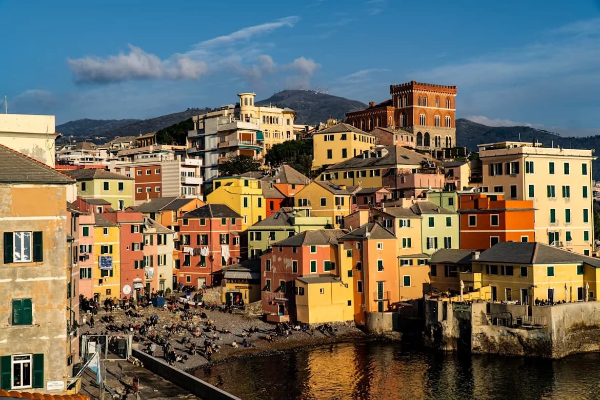 A cluster of colorful, traditional houses cling to a hillside overlooking a tranquil harbor.