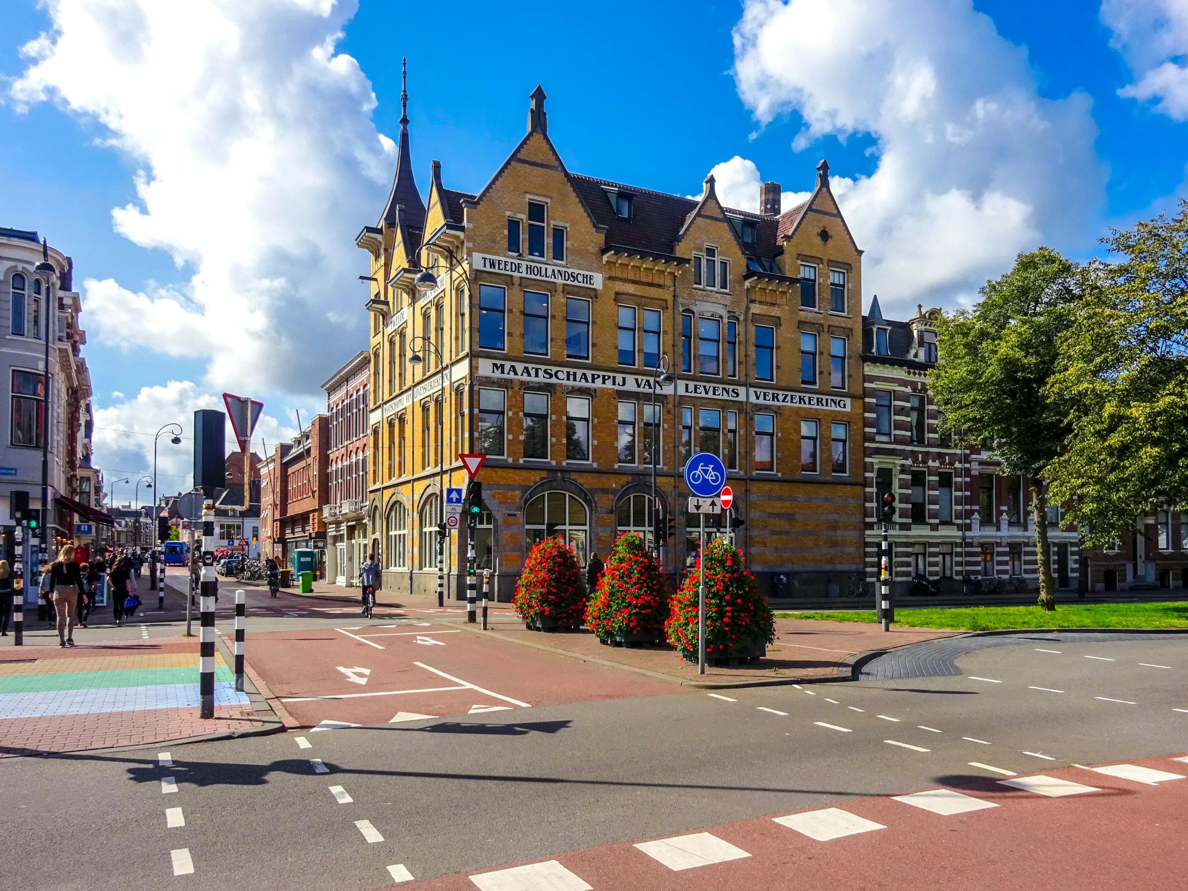 The historic, gabled facades of traditional buildings stand at a busy intersection in the center of Haarlem.