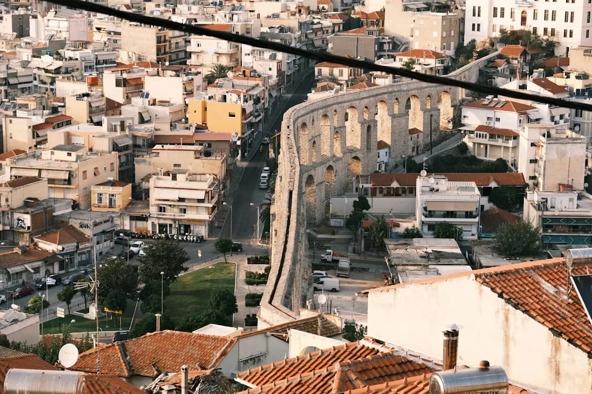 The ancient Roman Aqueduct of Kavala, a series of stone arches, winds through the city's residential buildings.