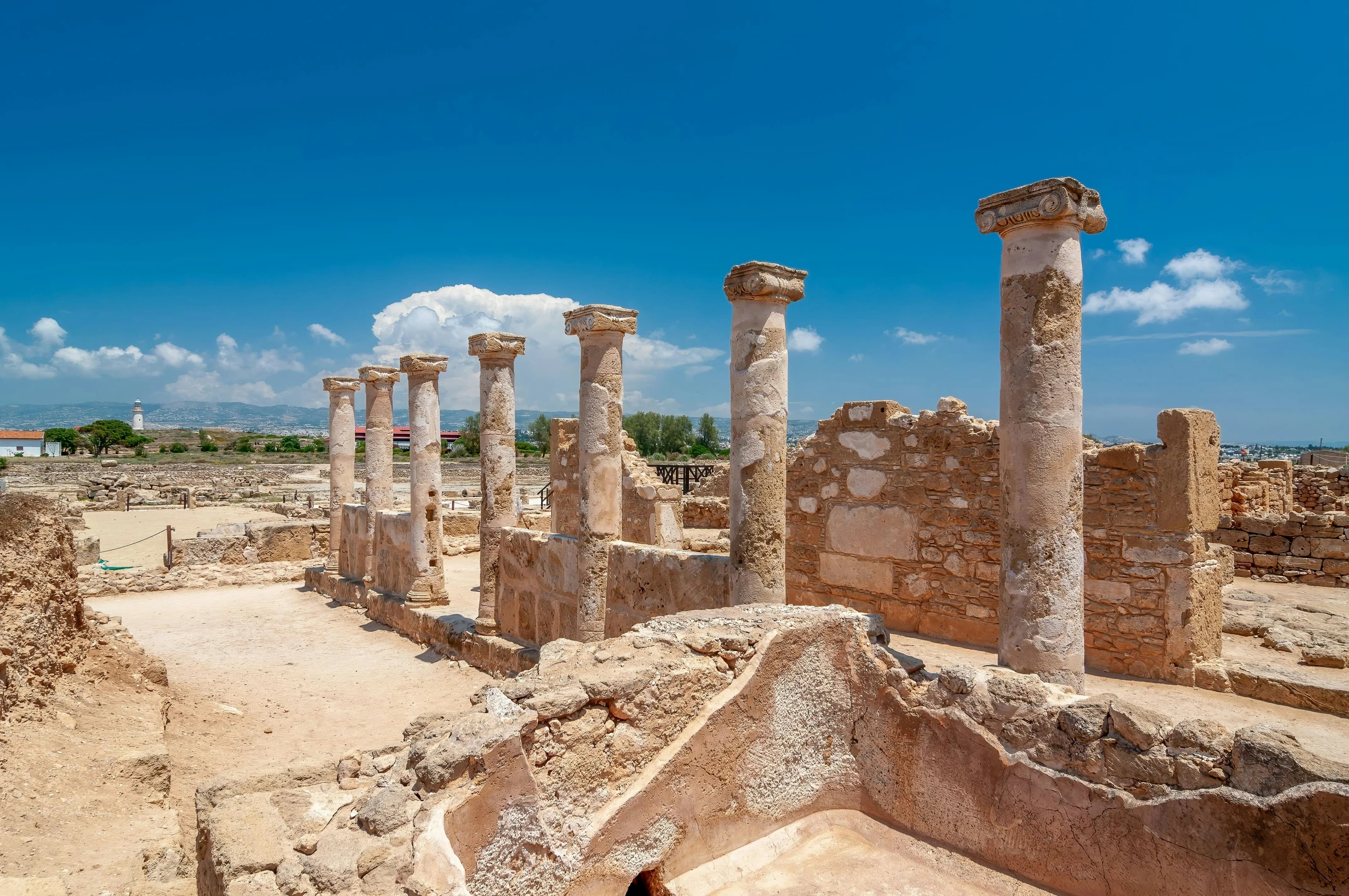 A series of ancient Roman columns stand among the ruins of the House of Aion in the Paphos Archaeological Park.