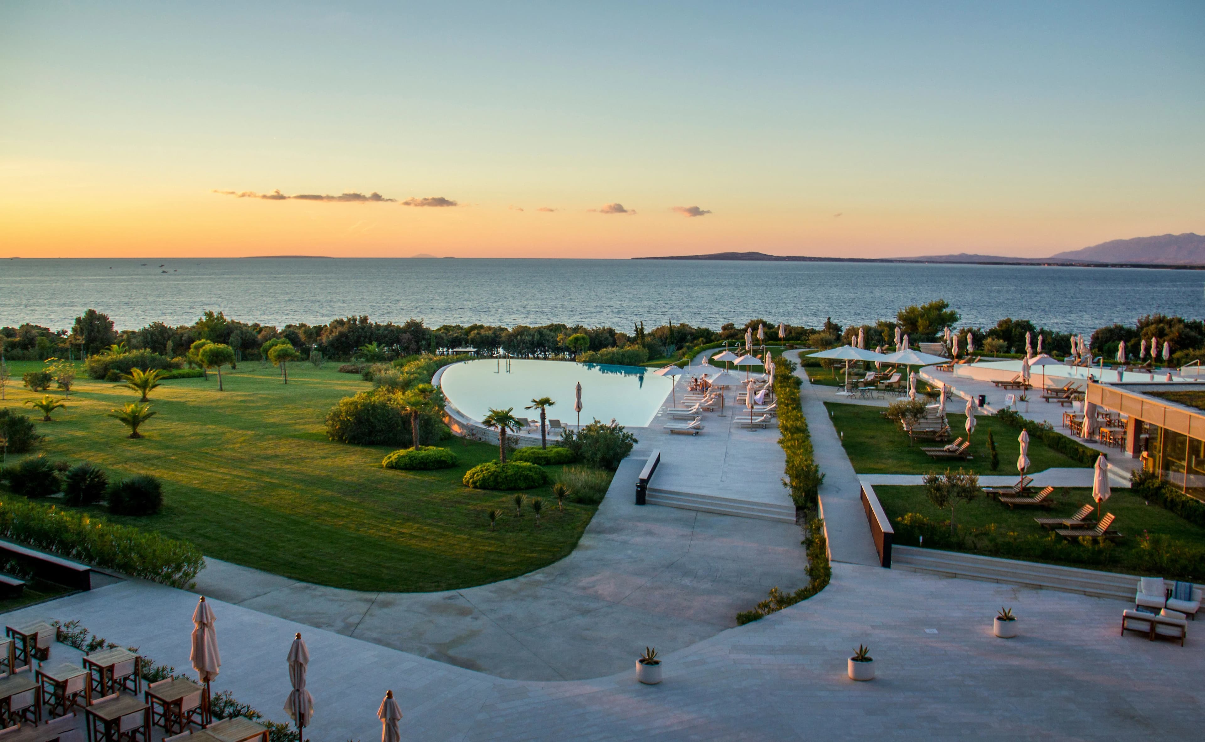 A luxurious resort pool overlooking the Adriatic Sea provides a perfect spot to relax and enjoy the sunset.