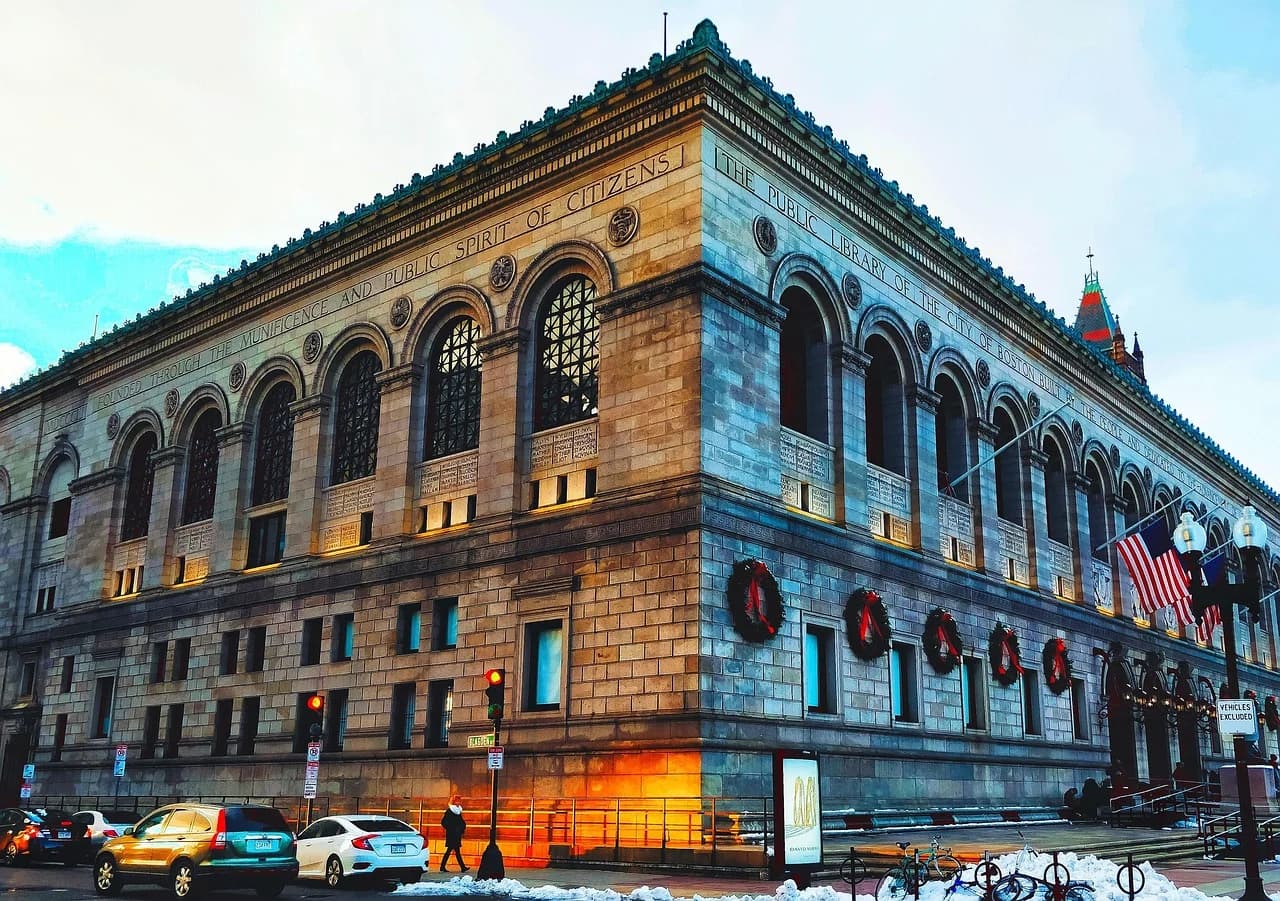 The grand facade of the Boston Public Library, a historic landmark, is decorated with holiday wreaths.