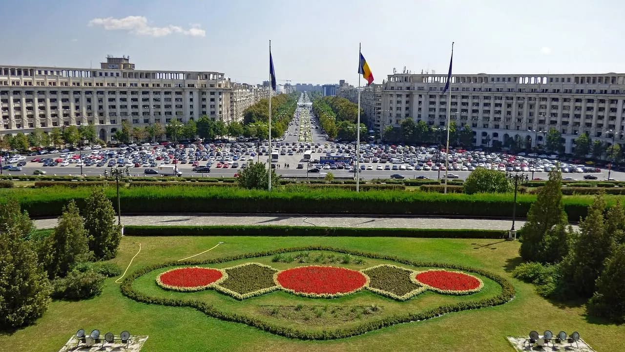 The Palace of the Parliament, a monumental building, stands at the end of a long, wide boulevard.