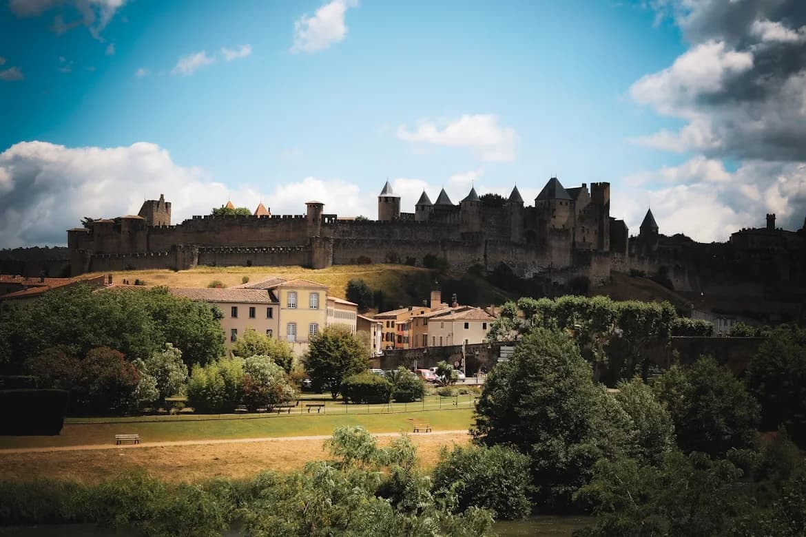 The imposing medieval walls and towers of Carcassonne stand tall on a hill, overlooking the town below.