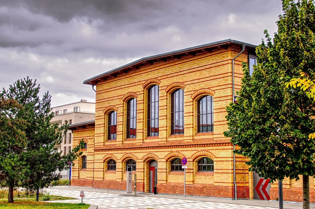 A group of people dressed in traditional costumes marches through a city street, celebrating a local festival.