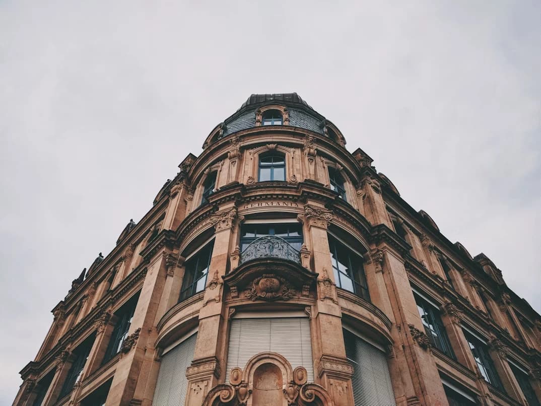 The intricate facade of a classic art nouveau building is viewed from a low angle, showcasing its ornate details.