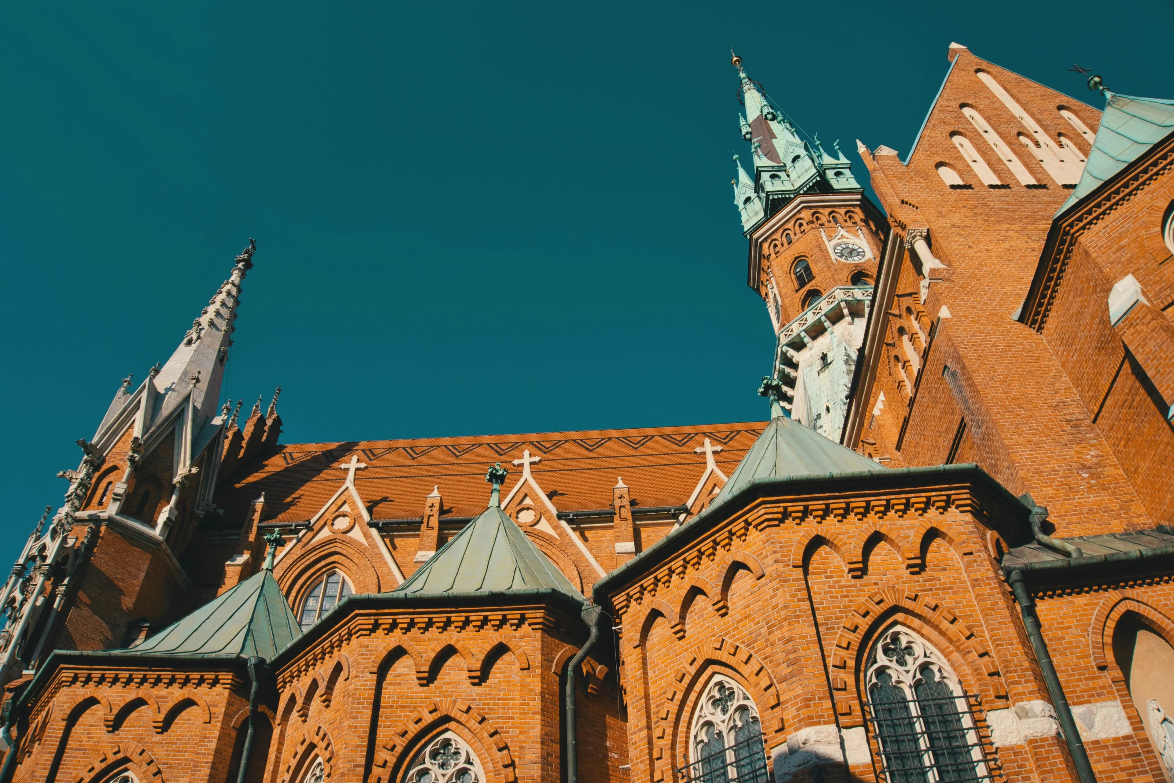 The intricate brickwork and gothic spires of St. Mary's Basilica soar against a vibrant blue sky.