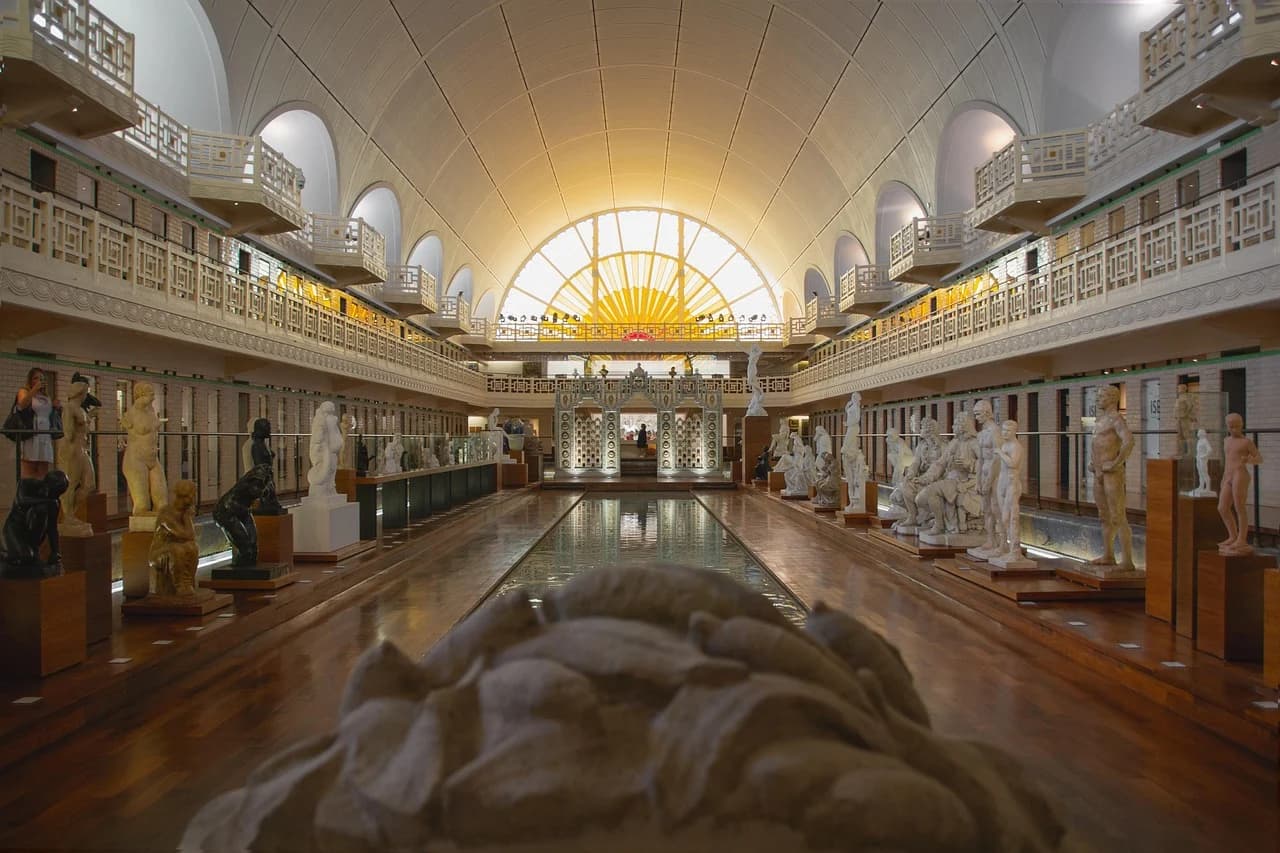 The stunning art deco interior of La Piscine Museum, a former swimming pool, showcases a grand collection of sculptures and art.