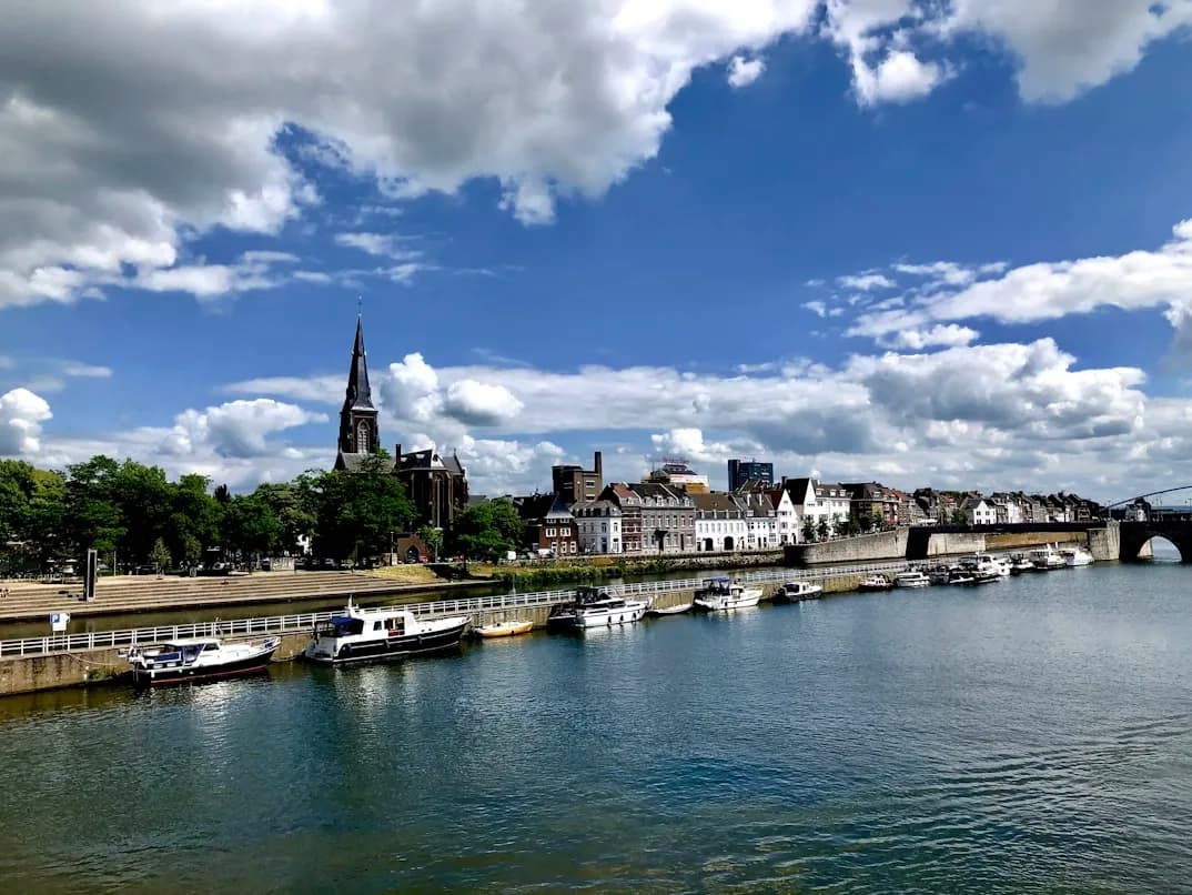 A quiet, cobblestone street in Maastricht is lined with traditional brick houses and small cafes.