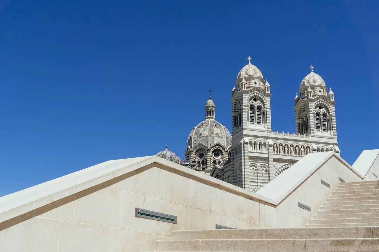 The magnificent domes and spires of the Basilique Notre-Dame de la Garde are a beautiful sight against a clear blue sky.