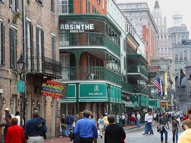 The bustling streets of the French Quarter are lined with traditional buildings with cast-iron balconies and numerous signs from local pubs and bars.