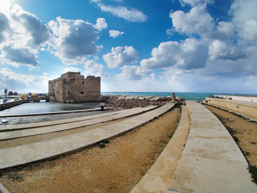 Paphos Castle, a historical landmark, sits on the edge of the harbor, with a causeway connecting it to the mainland.