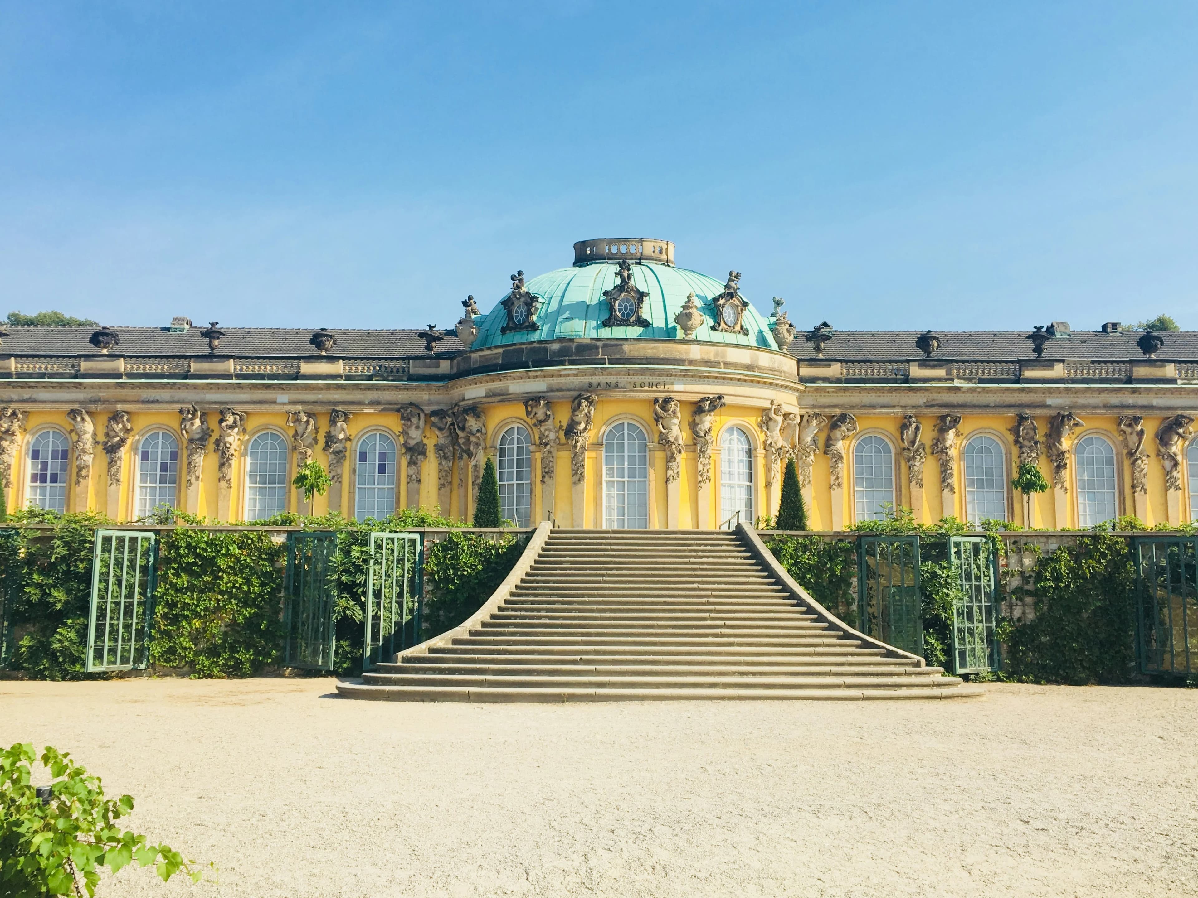 The stunning Sanssouci Palace, with its yellow facade and green dome, is a beautiful example of rococo architecture.