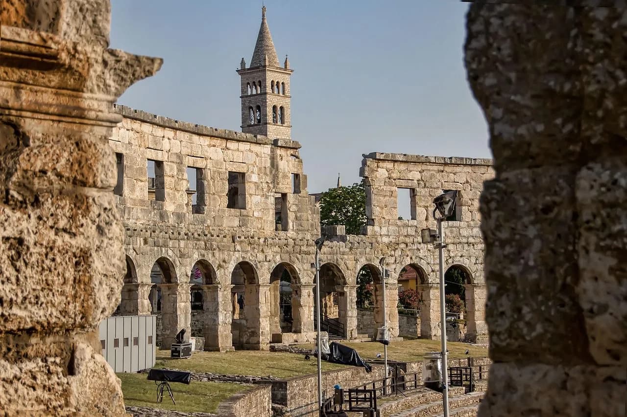 A view from inside the Pula Arena captures the medieval bell tower of the Church of St. Francis and the historic ruins.