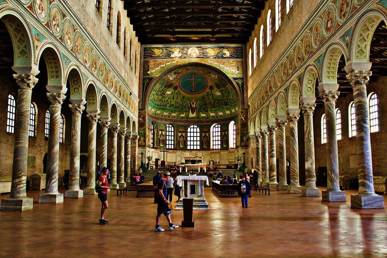 The magnificent interior of the Basilica of Sant'Apollinare Nuovo, with its intricate mosaics and columns, is a stunning sight.