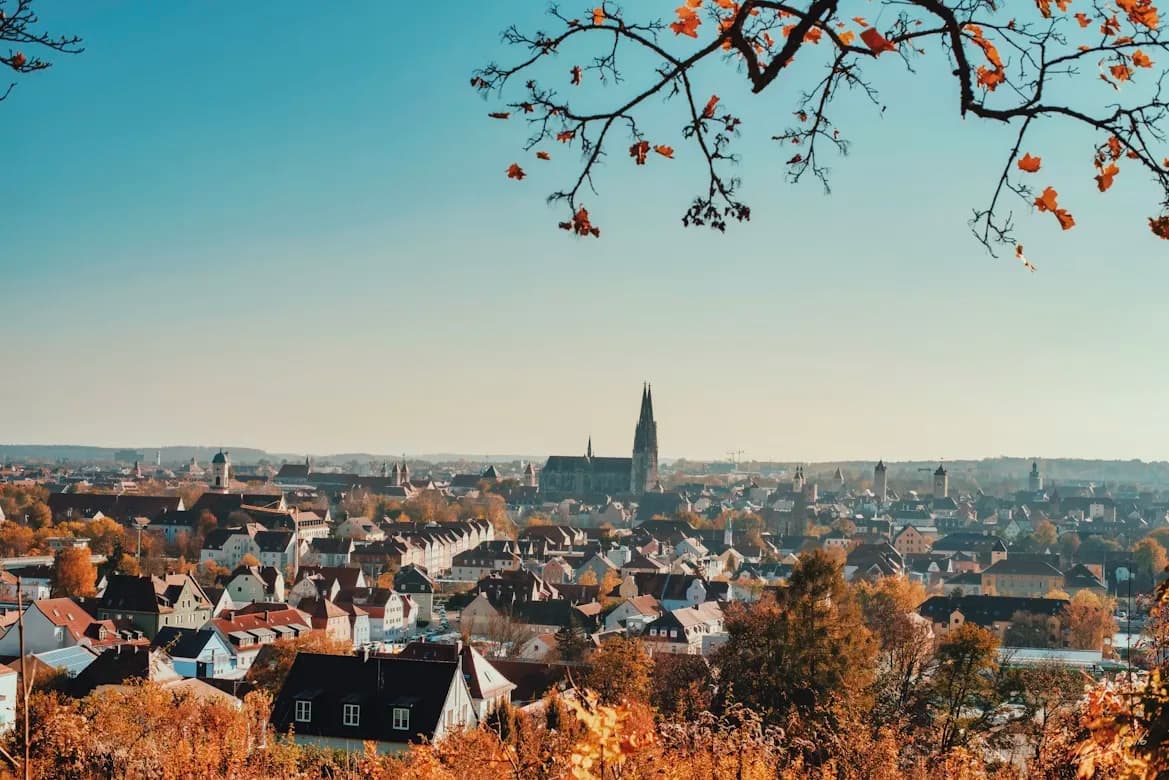 A scenic view of the Regensburg skyline, with the towers of the Dom of St. Peter rising above the red rooftops.