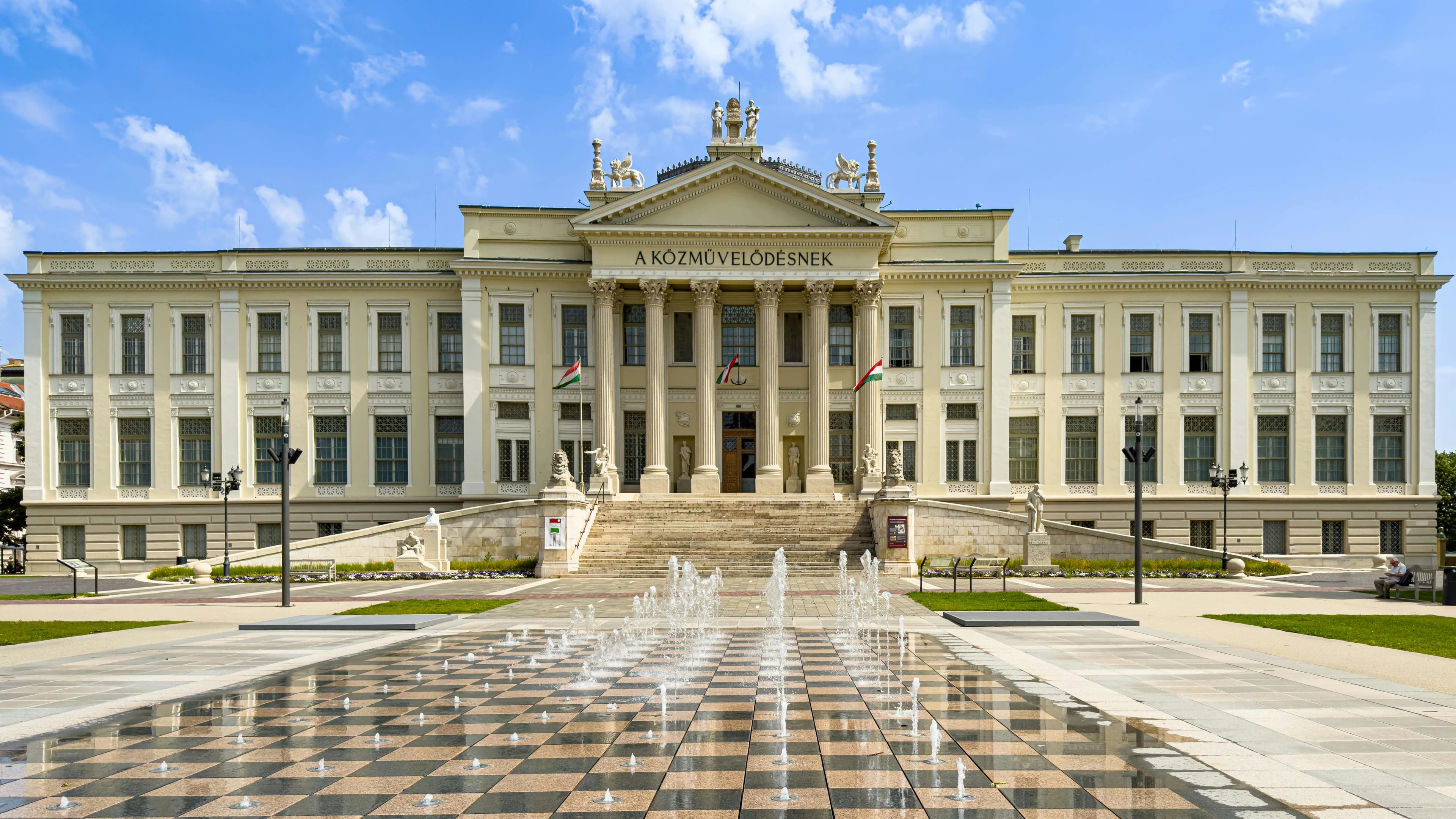 A historic building with a large clock tower and an intricate facade is a prominent landmark of the Dóm Square.