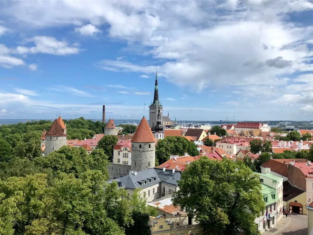A narrow, cobblestone alleyway in Tallinn's Old Town is filled with bustling restaurants and cafes.