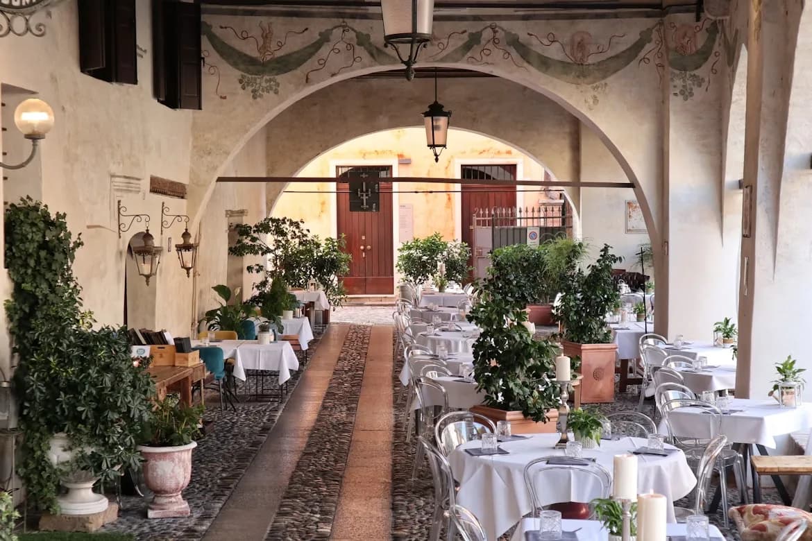 A quiet city street in Treviso is lined with elegant, traditional buildings with a few small shops and cafes.