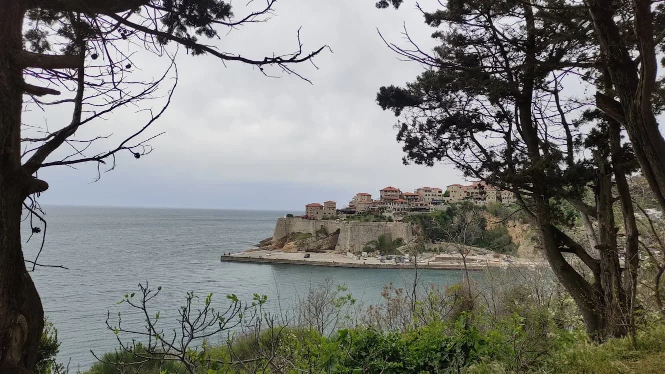 A panoramic view of the beautiful coastline, with a wide bay and the historic town of Ulcinj on a hill.