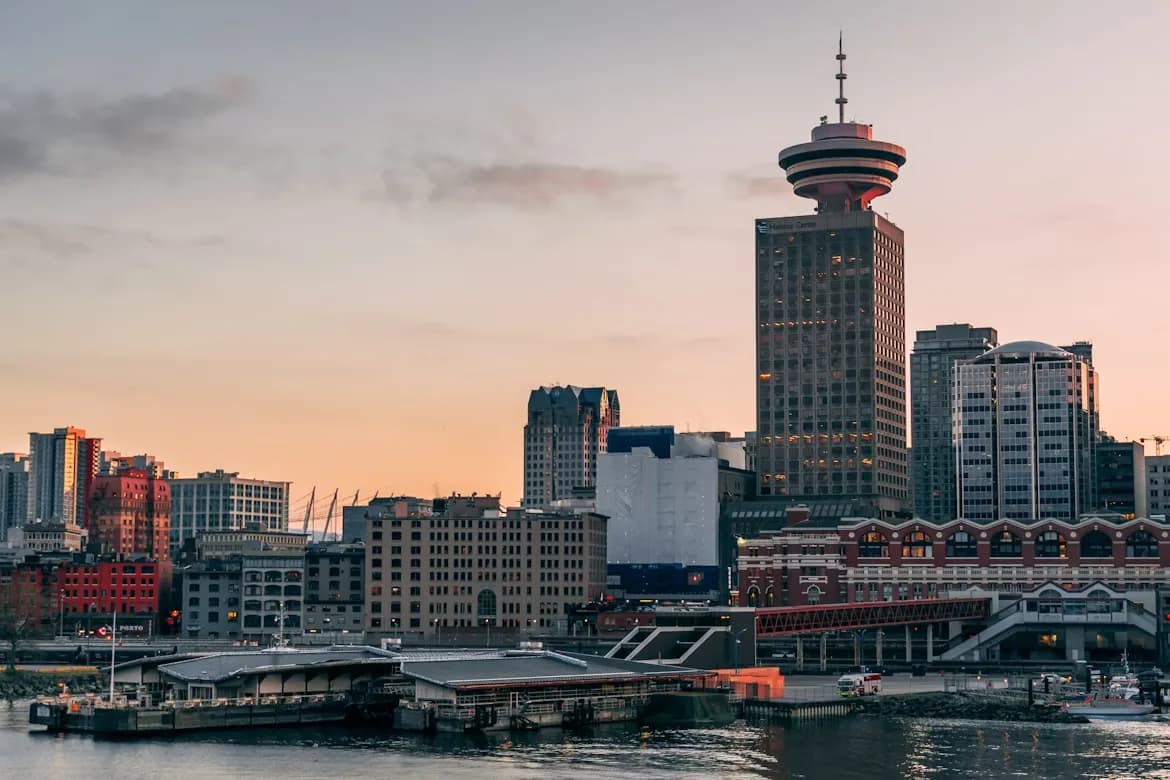 A picturesque view of the Vancouver skyline from Stanley Park, with the city's modern skyscrapers and the sea.