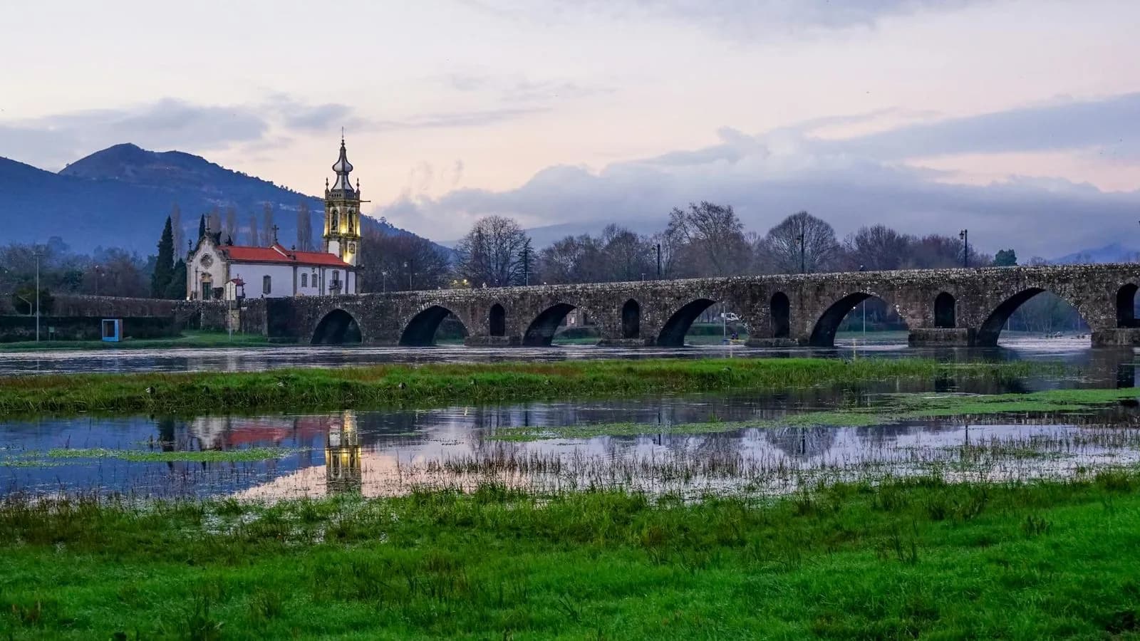 The iconic Gil Eannes hospital ship is a prominent feature of the Viana do Castelo harbor, with fishing boats and modern buildings in the background.