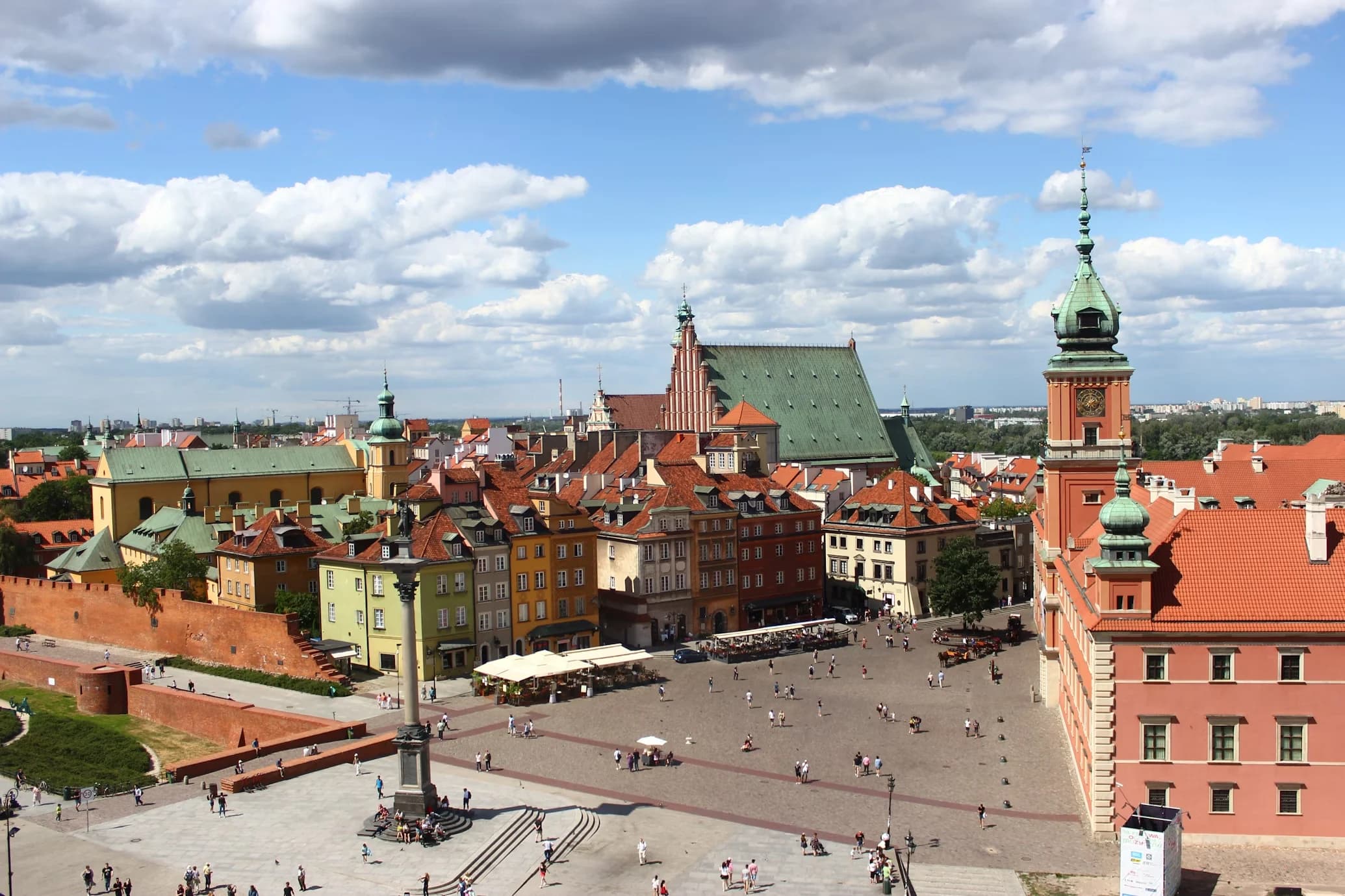 An aerial view of Warsaw's Old Town, with its cobblestone square and a mix of historic and modern buildings.